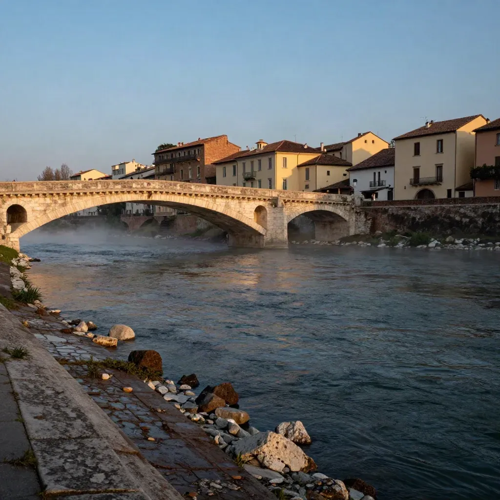 L’Adige al crepuscolo, ponte in pietra in diagonale e facciate pallide riflesse nell’acqua.